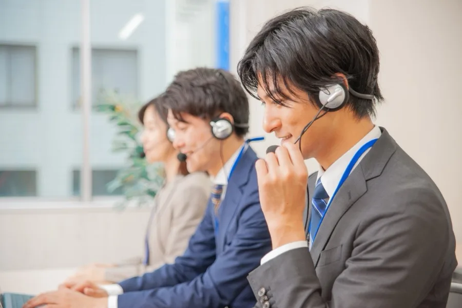 ヘッドセットで電話対応するスタッフ